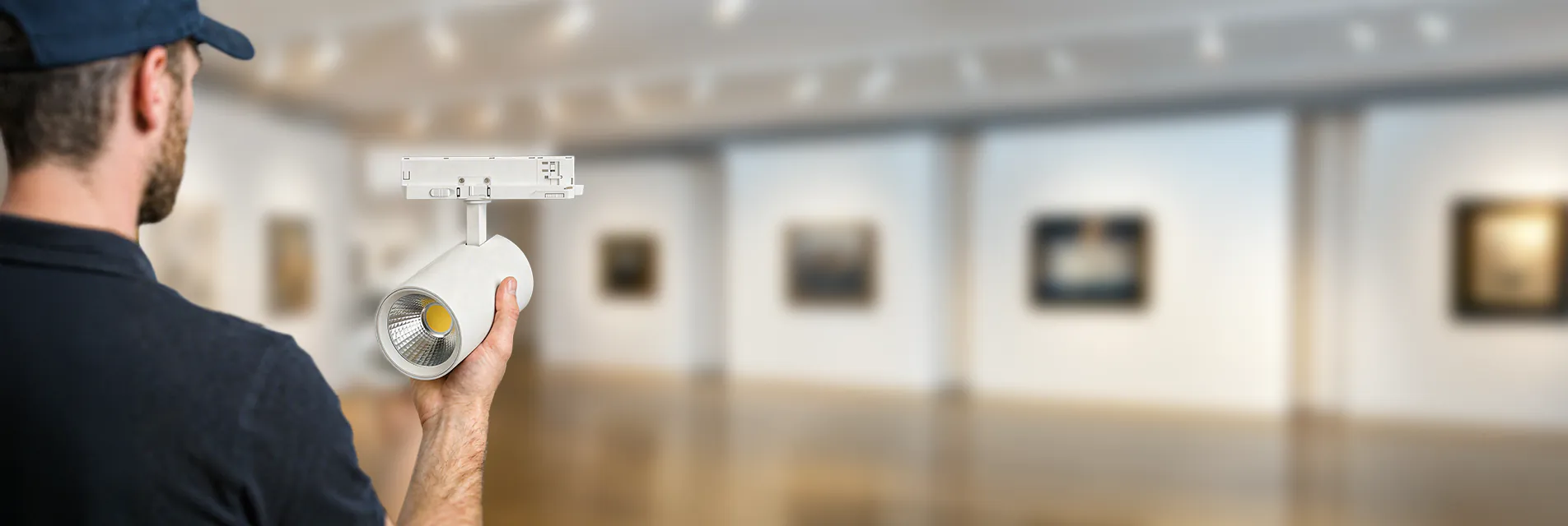 Mann hält einen Noxion Schienenstrahler in einem Museum in der Hand.